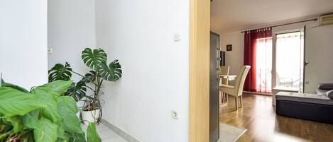 A modern apartment with a living area, a dining space, and a balcony.