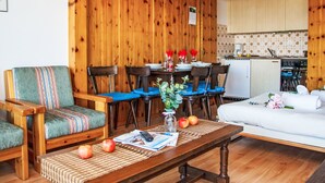 A cozy wooden-furnished living room with a dining area, a kitchen, and a bed. - Christiania 2 O3 by Interhome (Nendaz)