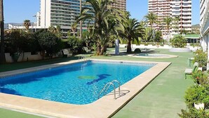 A swimming pool with a clear blue water, surrounded by palm trees and greenery. - Esmeralda 02 by Interhome (Calpe/Calp)