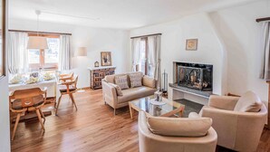Un salon comprenant un canapé, des fauteuils, une table basse et une cheminée.