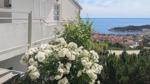 Un immeuble doté d’un balcon donnant sur une ville côtière et la mer.