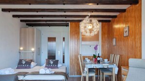 Una habitación acogedora con cama, una mesa de comedor con sillas y una araña.