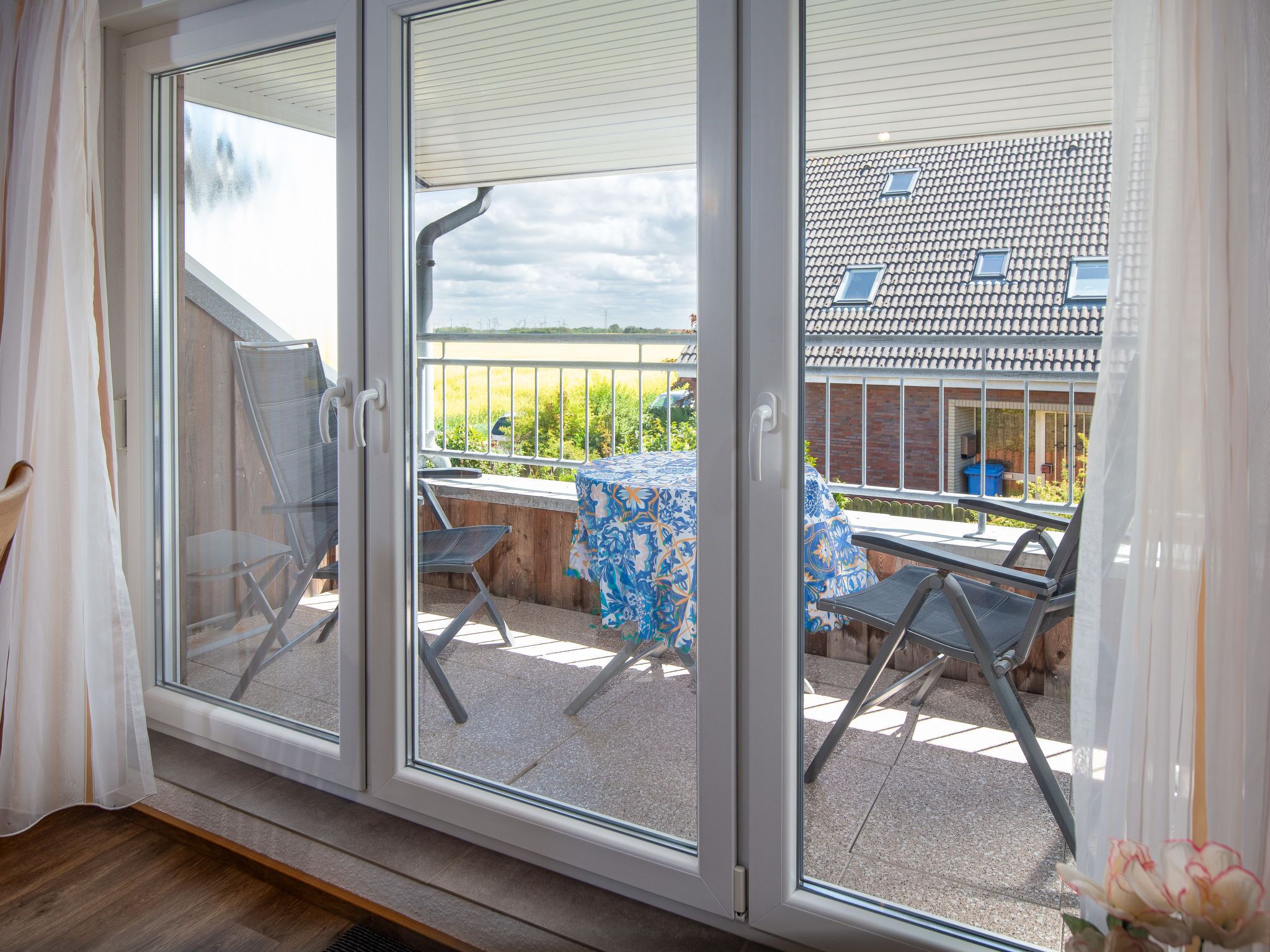 A room with a sliding glass door leading to an outdoor patio with a table and chairs.