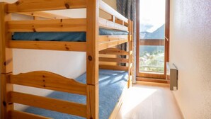 A bunk bed with a view of mountains through a window. - Vostok Zodiaque by Interhome (Le Corbier)