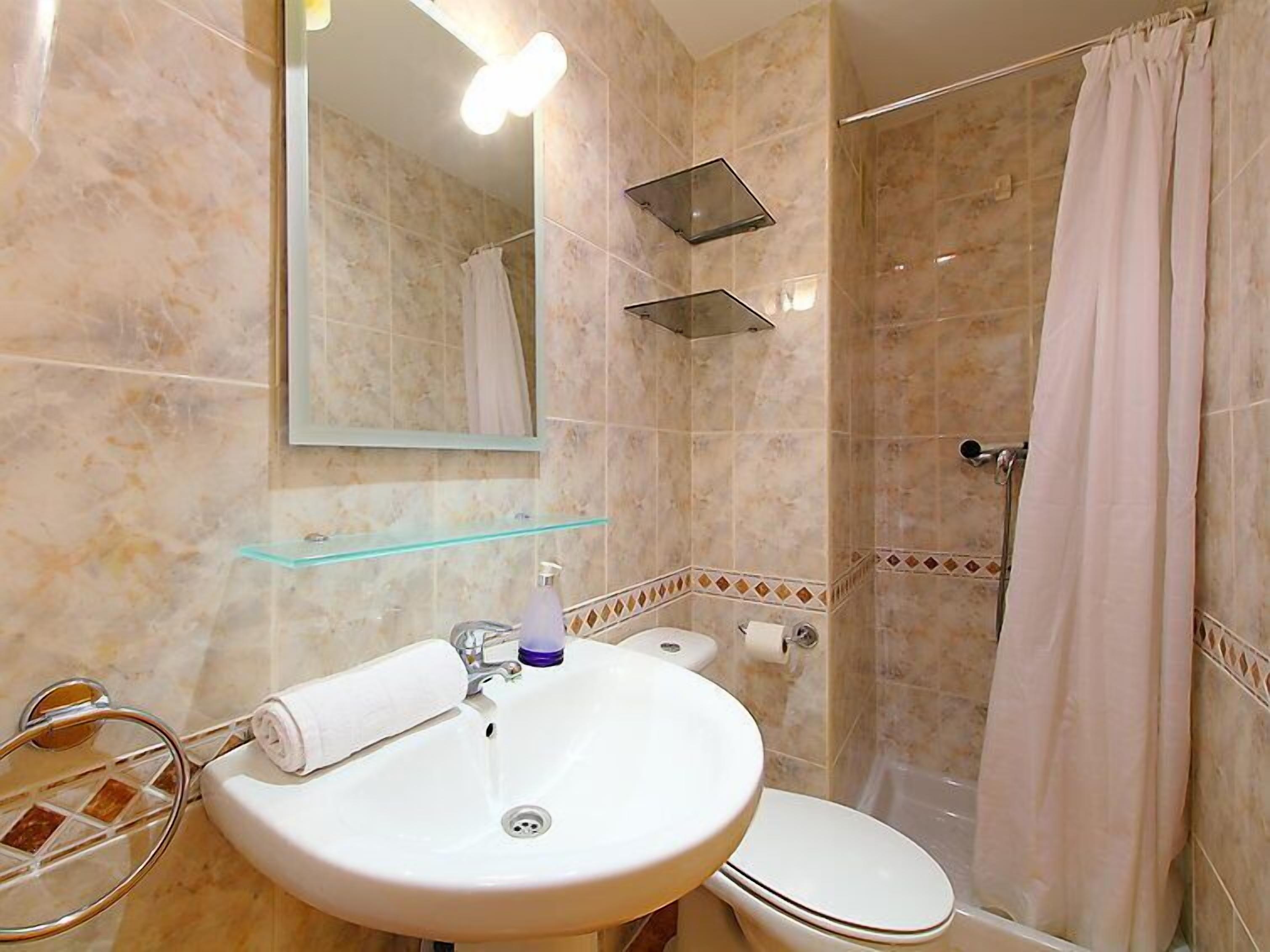 A bathroom with a sink, toilet, and shower.