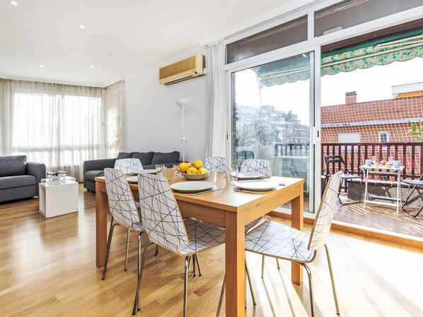 Un salon moderne avec un coin repas, comprenant une table à manger en bois, des chaises et un canapé.