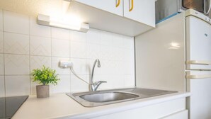 A kitchen with a stainless steel sink, a microwave, and a dishwasher. - Le Beaupré by Interhome (Canet-Plage)