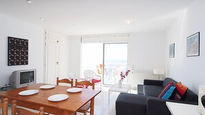 A modern living room with a dining area, a sofa, and a TV. - Prudenci by Interhome (Roses)