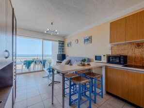 Una cocina moderna con una isla grande, armarios de madera y vistas al exterior.
