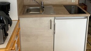 A compact kitchen with a sink, a coffee machine, and a small refrigerator. - Muschelweg by Interhome (Norddeich)
