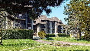 A modern multi-story residential building with a well-maintained lawn and pathway leading to the entrance. - Le Garden Fleuri by Interhome (Blonville sur mer)