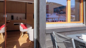 A modern kitchen with wooden cabinets and a dining area with a table and chairs. - Ecluses 2 by Interhome (Nendaz)