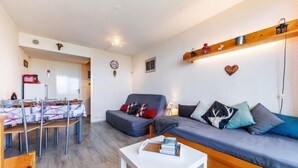 Un salon confortable avec un canapé, une table basse et un coin repas comprenant des chaises et une table.