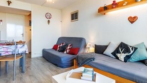 Un salon confortable avec un canapé, une table basse et un coin repas comprenant une table et des chaises.