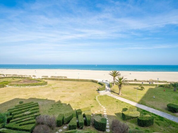 A landscaped garden with a pathway leading to a beach.