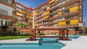Un hôtel à plusieurs étages doté d’une piscine, de balcons et d’une façade en briques rouges.