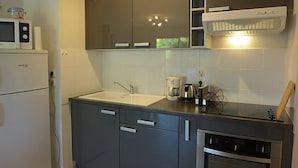 Una cocina moderna con microondas, lavaplatos y fregadero.