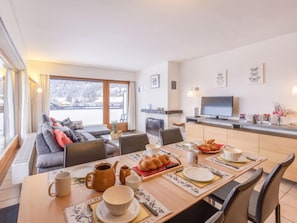 Relax in this cozy living space with a fireplace, flat-screen TV, and a dining area.