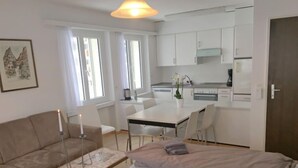 A modern apartment with a living area, a dining table, and a kitchenette. - Val Signina by Interhome (Laax)