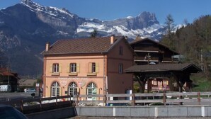 Un edificio con un letrero que dice "TRAMWAY DU MONT BLANC" al frente de un telón de fondo de montaña.