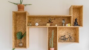 Une étagère en bois sur laquelle sont disposés divers objets, notamment une horloge, un vélo et des plantes.