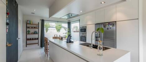 Enjoy cooking in this well-equipped kitchen with a central island, sink, and refrigerator.