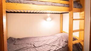 A bunk bed with a headboard and a window. - Balcons d'Olympie 204 - A by Interhome (Les Menuires)