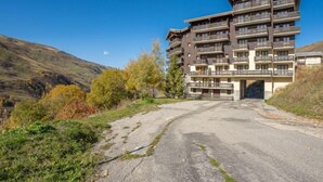 A multi-story hotel with balconies, situated in a hilly area with autumn foliage. - Balcons d'Olympie 204 - A by Interhome (Les Menuires)