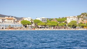 Un pueblo costero con playa, edificios y árboles.