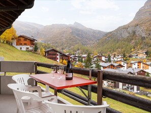 A terrace with a table and chairs, overlooking a village and mountains. - Apartment Alba by Interhome (Zermatt)