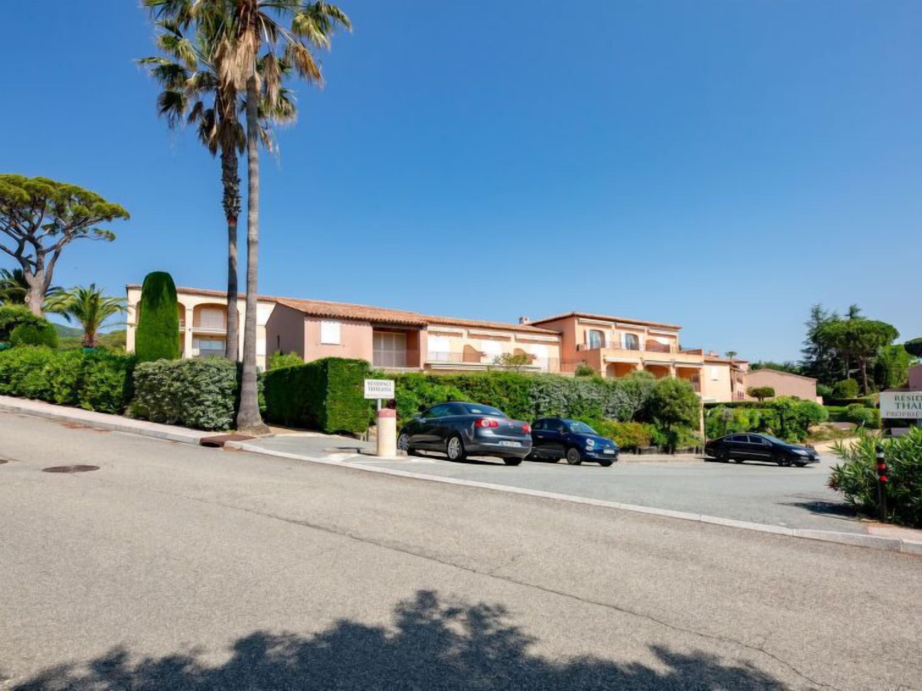 A residential area with a row of houses, parked cars, and a clear blue sky.