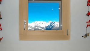 A window with a clear view of snow-capped mountains under a blue sky. - Le Ruisseau by Interhome (Nendaz)