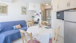 A compact living space with a kitchenette, a dining area, and a bedroom. - Les Rives Latines by Interhome (Fréjus)