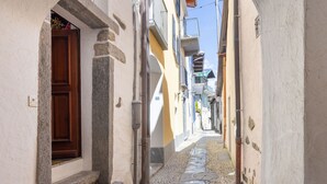 A narrow cobblestone street flanked by buildings with stone steps leading to doors. - Casa Eduardo Apt.1 by Interhome (Ronco sopra Ascona)
