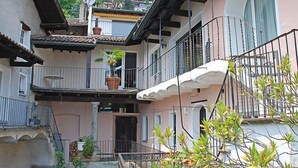 A multi-story building with balconies, a satellite dish, and potted plants. - Casa Eduardo Apt.1 by Interhome (Ronco sopra Ascona)