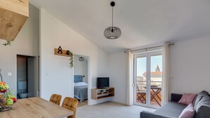 A modern apartment with a dining area, a living room with a sofa, a TV, and a balcony with a view. - Apartment Bonex by Interhome (Privlaka)