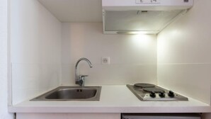 A compact kitchen with a stainless steel sink, a built-in stove, and a dishwasher. - Chalet Club (Val Claret) by Interhome (Tignes)