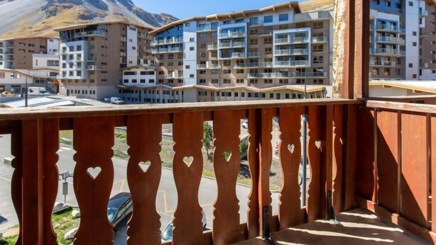 A modern apartment complex with multiple balconies, a mountain backdrop, and a clear sky. - Chalet Club (Val Claret) by Interhome (Tignes)