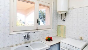 A kitchen with a double sink, a stove, a window, and a water heater. - Cap de Vol by Interhome (Llançà)