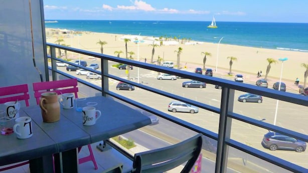 Ein Balkon mit Blick auf Strand und Parkplatz.
