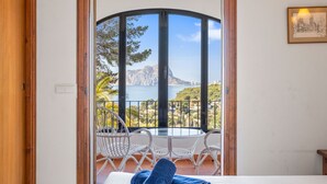 Ein Schlafzimmer mit Balkon und Blick auf eine malerische Küstenlandschaft.