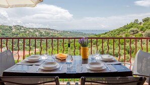 A table set for two with a view of a coastal landscape.