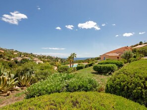 Ein Anwesen an einem Hang mit einem großen Haus, üppiger Vegetation und Blick auf das Meer.