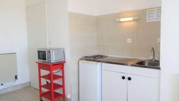 Een koelkast, kookgerei, borden en bestek