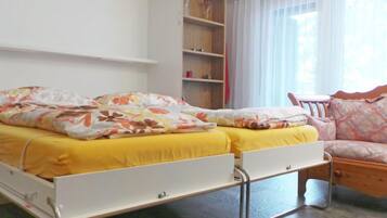 A bedroom with a bed, bedside tables, a chair, and a window with curtains.