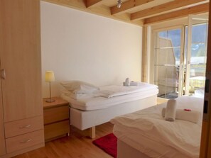 A bedroom with a bed, bedside table, lamp, and a wardrobe.