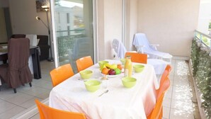 Een eetgedeelte met een tafel voor vier personen, omringd door oranje stoelen en een witte tafelkleed.