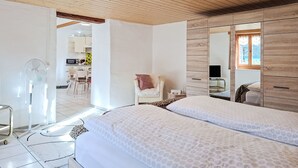 A bedroom with a wooden ceiling, a large mirror, and a bed with patterned bedding.