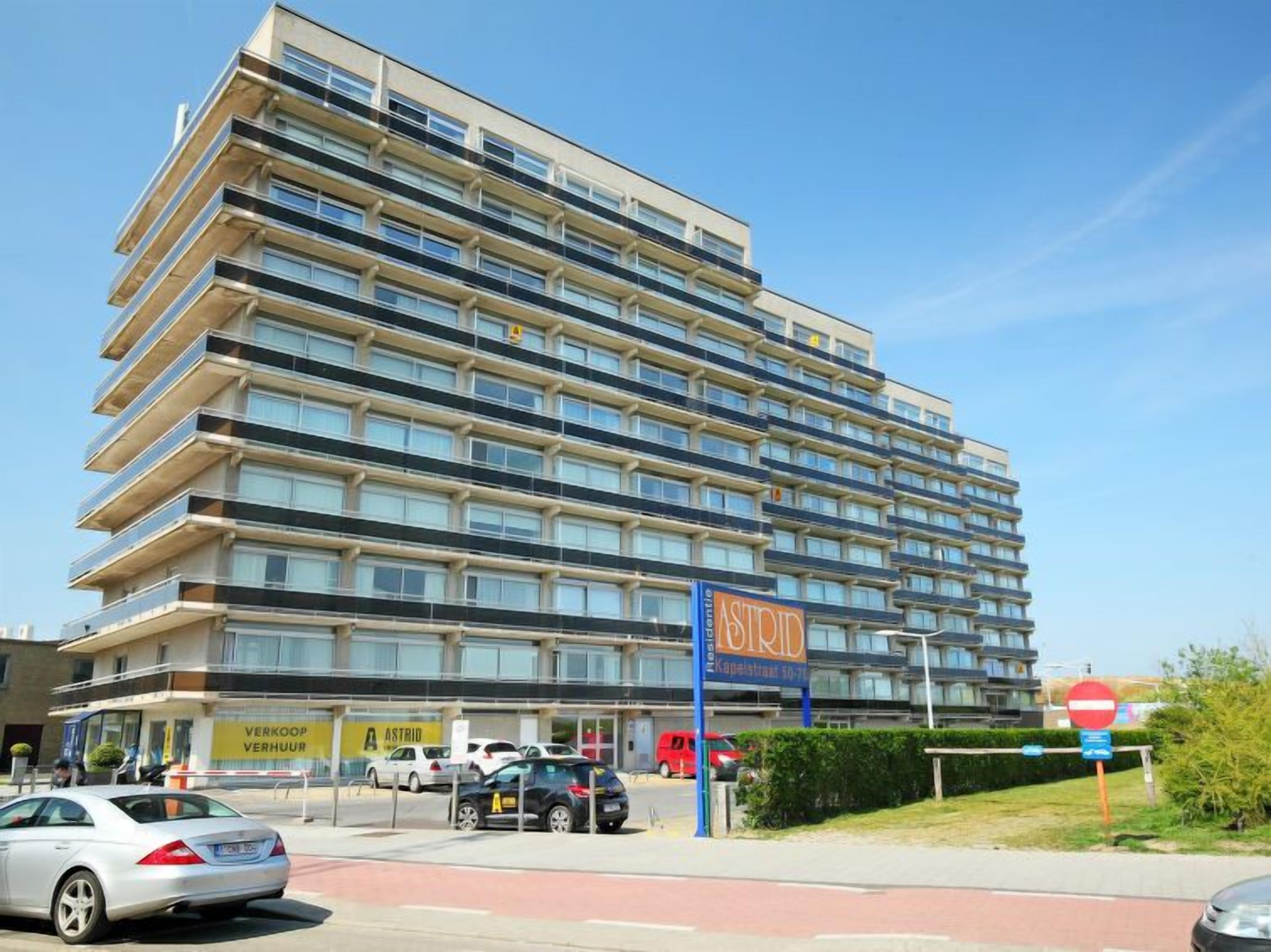 A multi-story hotel with a modern design, featuring balconies on each floor.