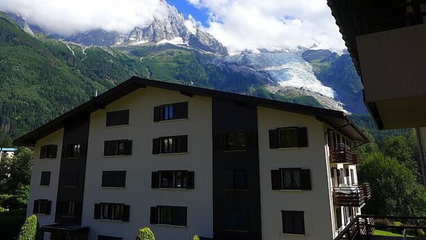 Ein mehrstöckiges Gebäude mit Bergblick, einschließlich eines markanten Gipfels und eines Gletschers.